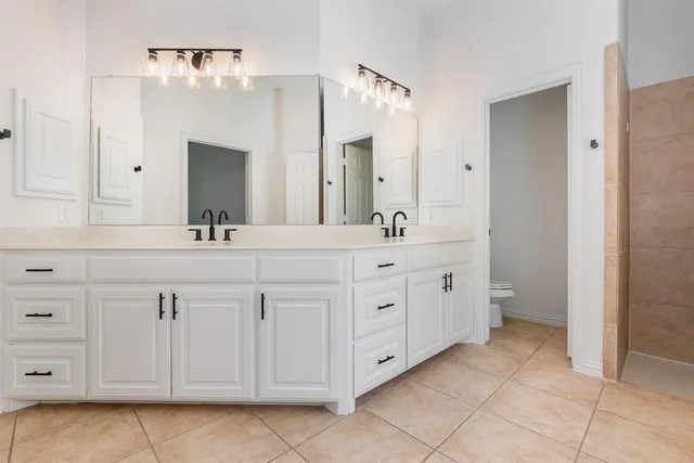 a spacious bathroom with double sink and a mirror