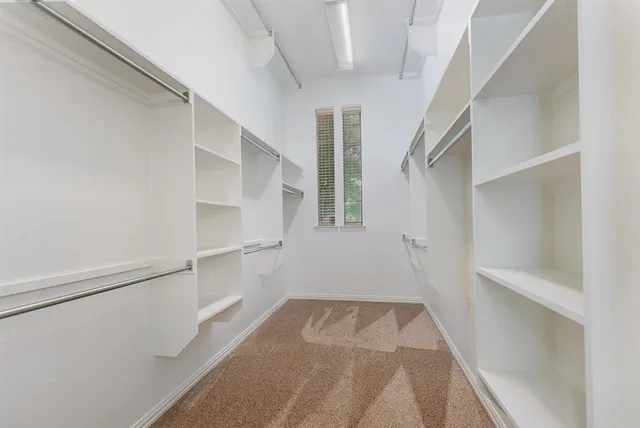 a view of walk in closet with empty racks