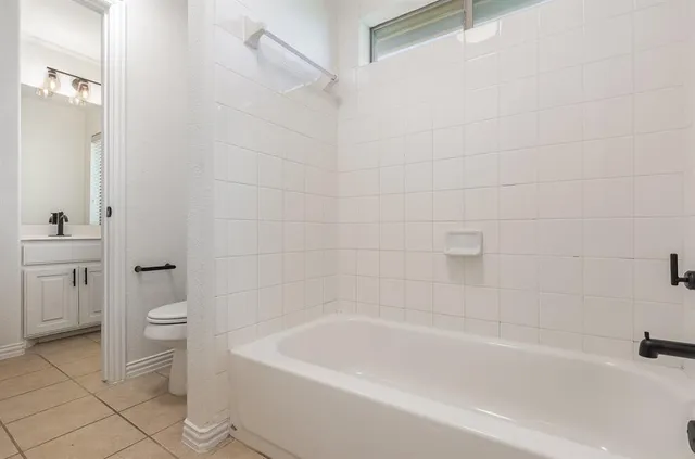 a bath room with a toilet and a bath tub