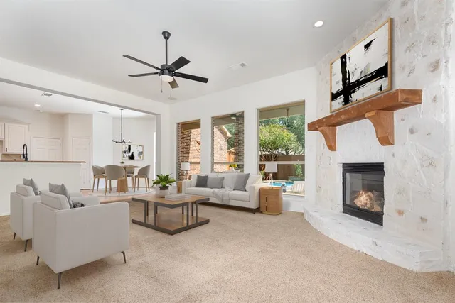 a living room with furniture a fireplace and a chandelier
