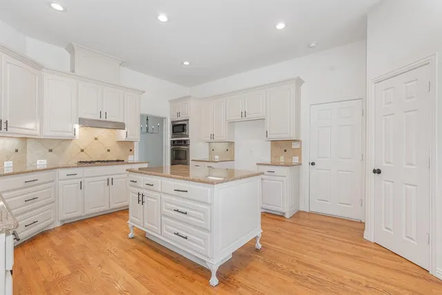 a kitchen with granite countertop white cabinets and white appliances