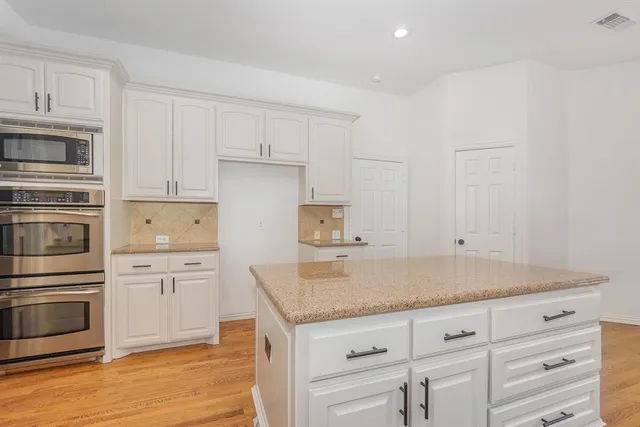 a kitchen with granite countertop cabinets stainless steel appliances and a counter space