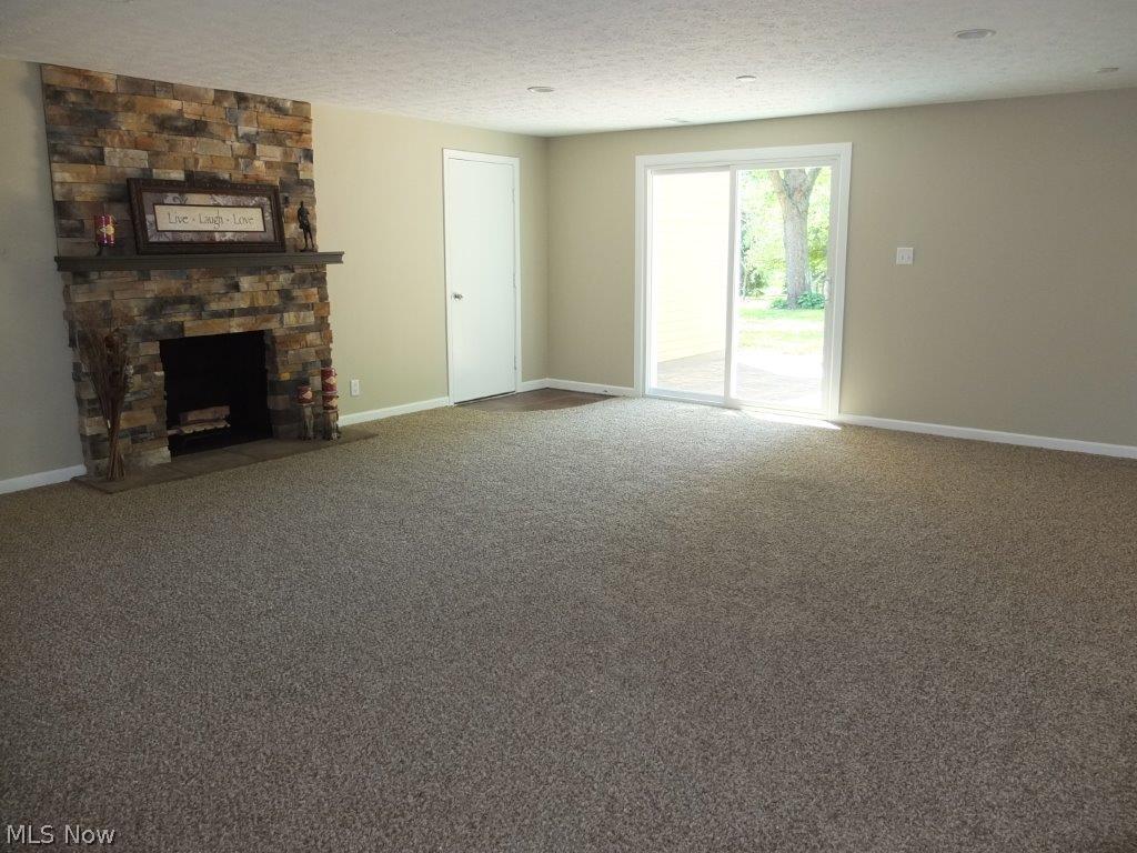 2555 Ranfield Road Mogadore, OH 44260 - Photo 3 of 25 Lower level family room with beautiful stone fireplace and slider to patio.