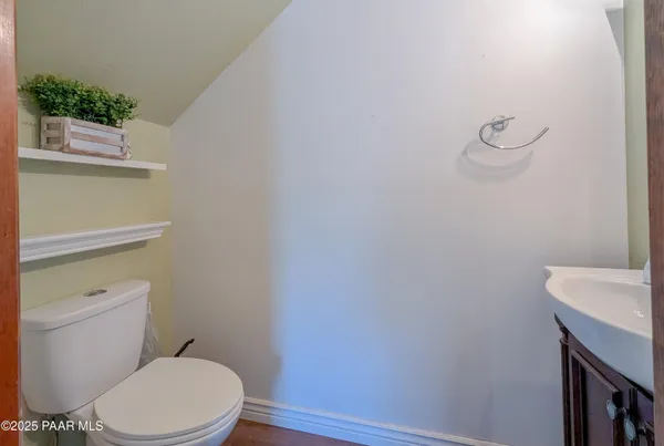 a white toilet sitting next to a white sink and vanity