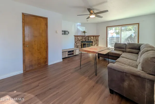 a living room with furniture and a wooden floor