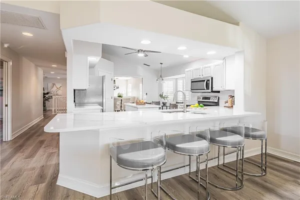 a kitchen with stainless steel appliances kitchen island granite countertop a sink and cabinets