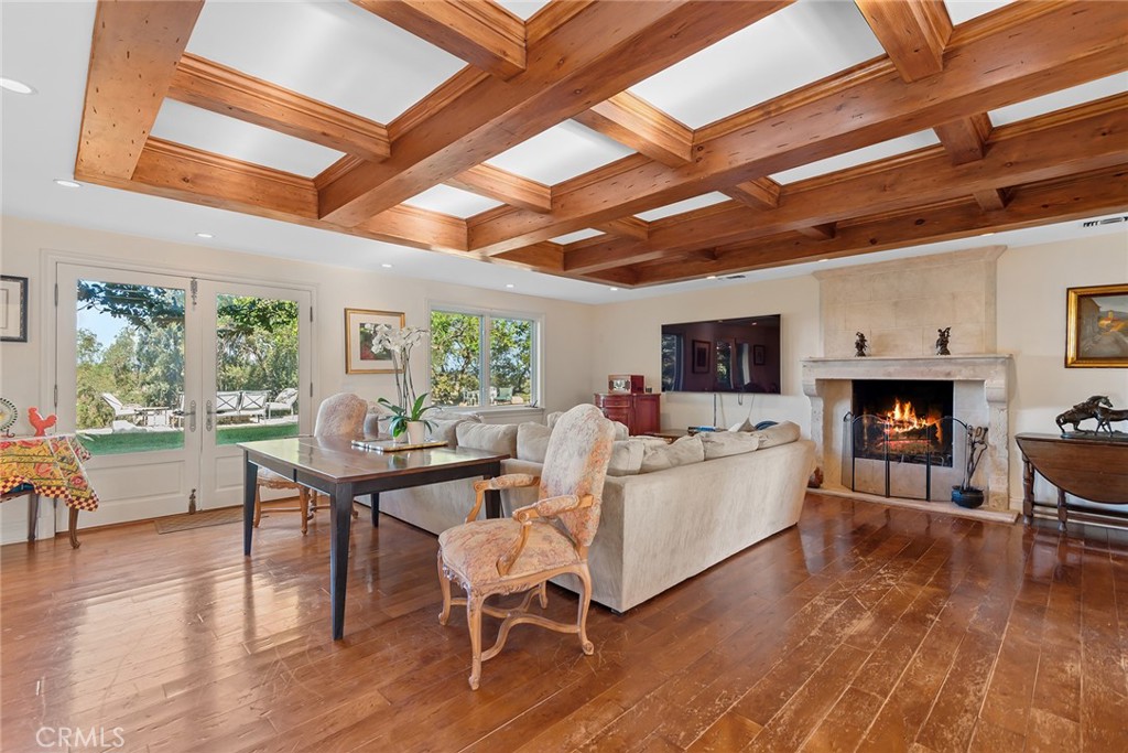 5747 Hoback Glen Road Hidden Hills, CA 91302 - Photo 10 of 37 a living room with furniture a fireplace a flat screen tv and wooden floor