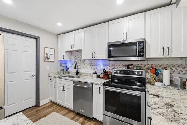 a kitchen with stainless steel appliances a stove a microwave sink and cabinets