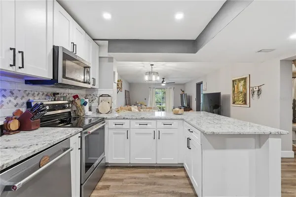 a kitchen with stainless steel appliances granite countertop a sink stove and cabinets