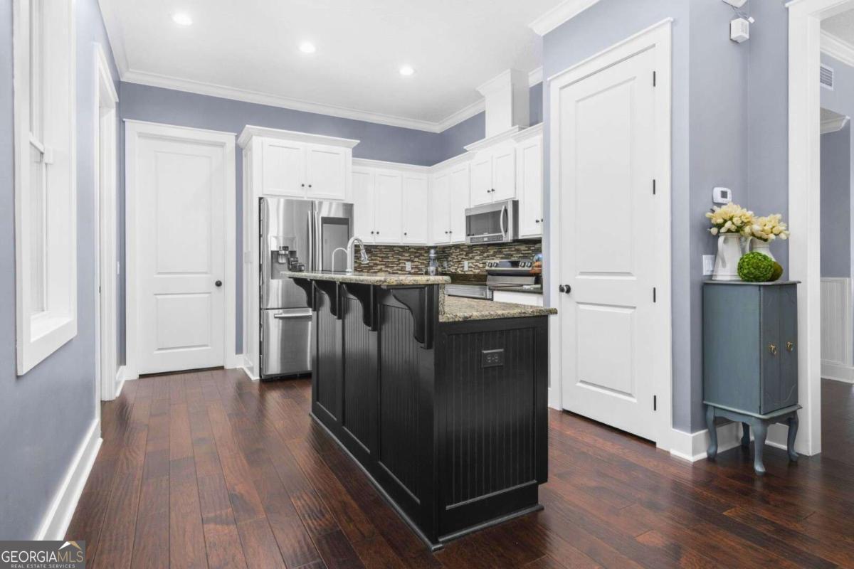 106 Boatsman Way St. Marys, GA 31558 - Photo 11 of 52 a kitchen with stainless steel appliances granite countertop a refrigerator a stove a sink and white cabinets with wooden floor