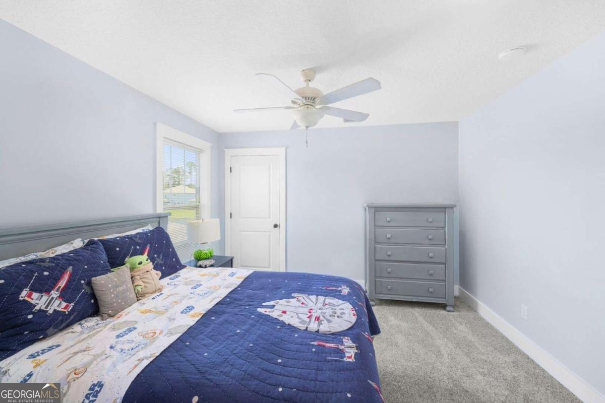 106 Boatsman Way St. Marys, GA 31558 - Photo 32 of 52 a bedroom with a bed and a chandelier