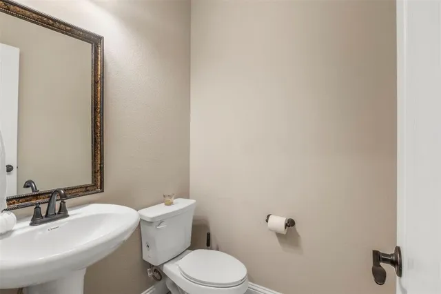 a white toilet sitting next to a bathroom sink