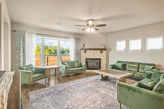 a living room with furniture a fireplace and a floor to ceiling window