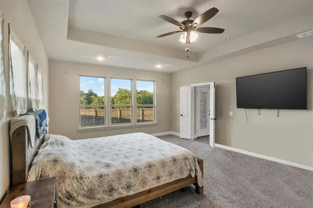a bedroom with a bed tv and a large window