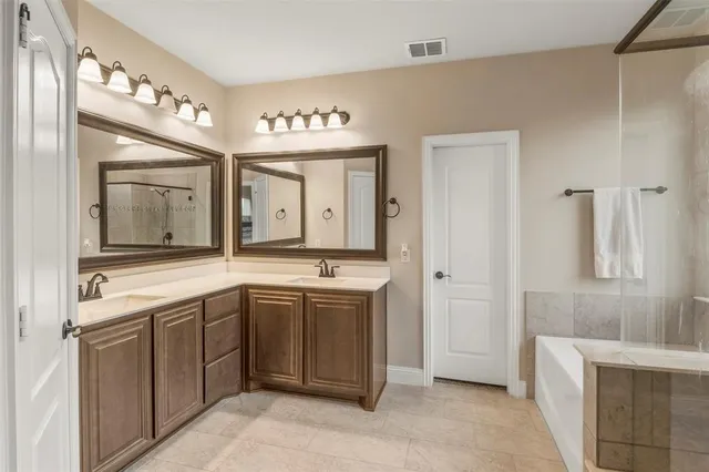 a spacious bathroom with a granite countertop sink mirror and bathtub