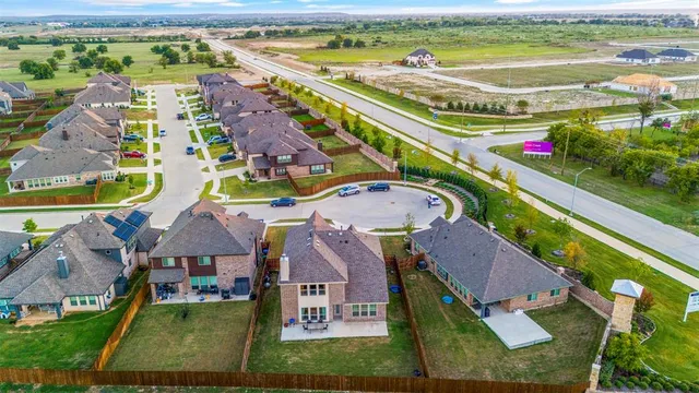 an aerial view of residential houses with outdoor space and swimming pool