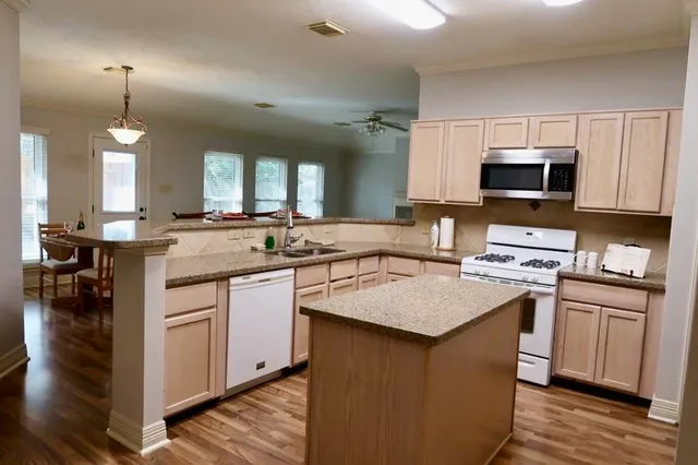 a kitchen with granite countertop a sink stove and cabinets