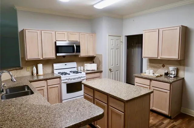 a kitchen with a stove sink and microwave