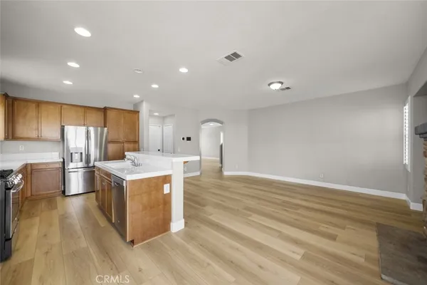 a kitchen with stainless steel appliances granite countertop a sink a stove and a refrigerator