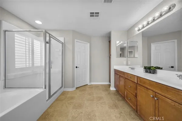 a large bathroom with a large mirror vanity and shower
