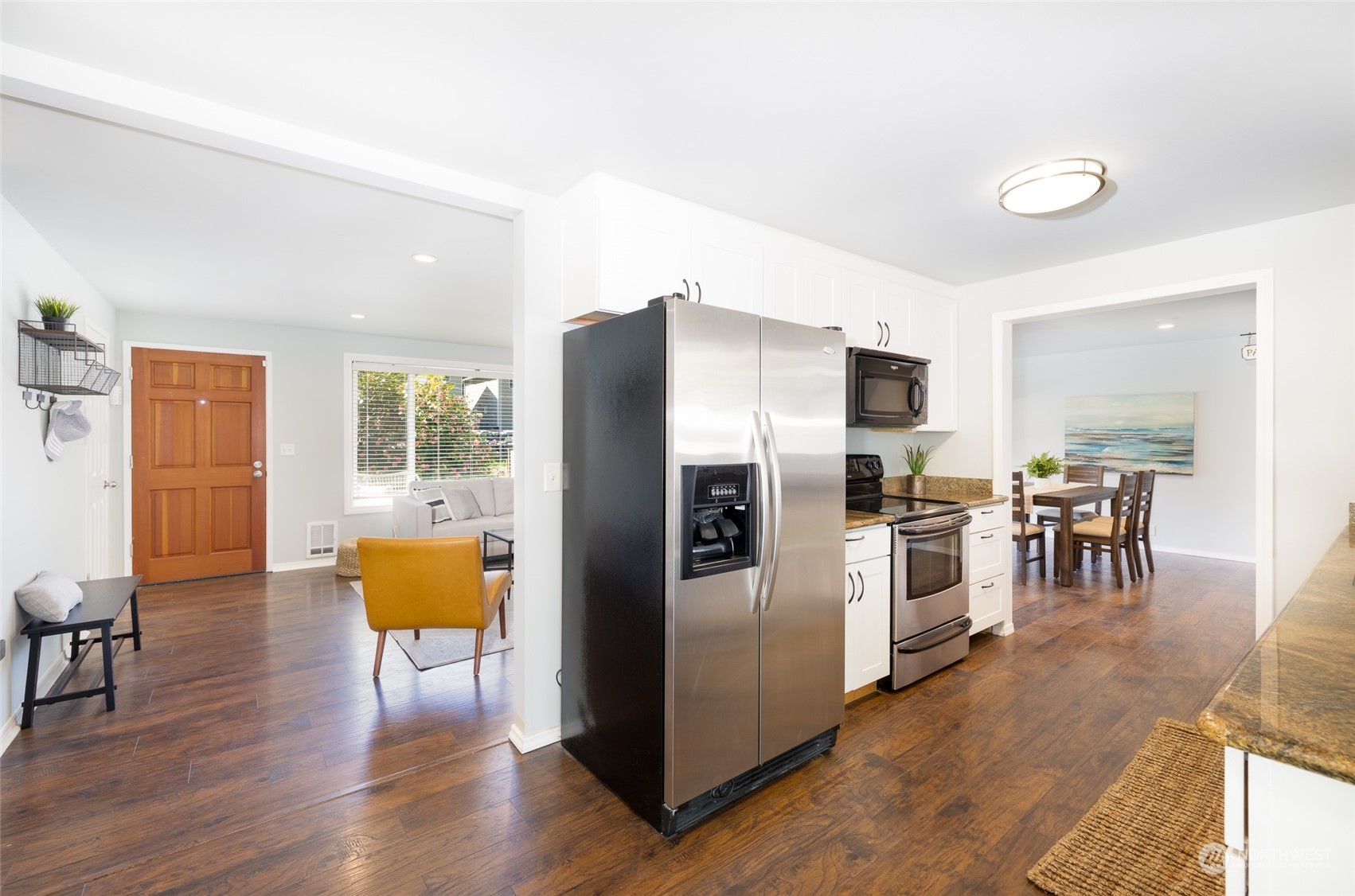 13411 Meridian Drive Southeast Everett, WA 98208 - Photo 10 of 20 a kitchen with stainless steel appliances a refrigerator a stove a dining table and chairs with wooden floor