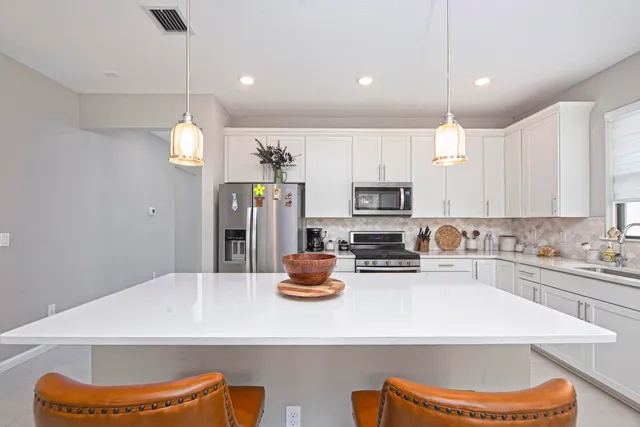 a kitchen with a sink a stove and chairs