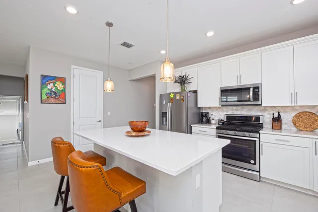 a kitchen with stainless steel appliances a stove a sink a microwave a refrigerator and cabinets