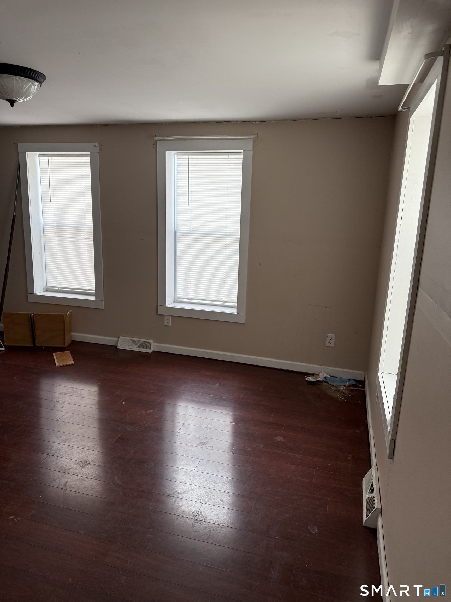 67 Summer Street Bristol, CT 06010 - Photo 18 of 31 an empty room with wooden floor and windows with curtains