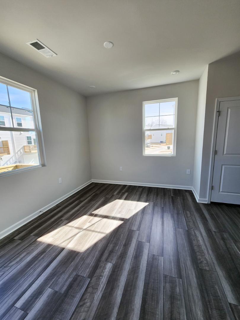 2431 Kasota Lane Raleigh, NC 27610 - Photo 15 of 59 wooden floor in an empty room with a window