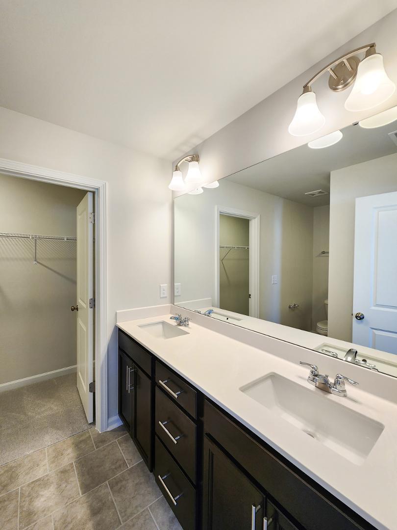 2431 Kasota Lane Raleigh, NC 27610 - Photo 37 of 59 a bathroom with a double vanity sink and a mirror