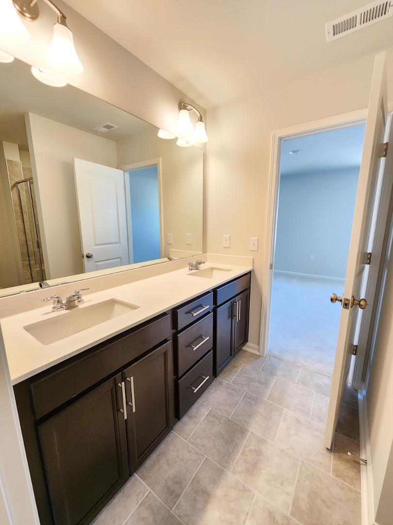 2431 Kasota Lane Raleigh, NC 27610 - Photo 39 of 59 a spacious bathroom with a double vanity sink a and mirror