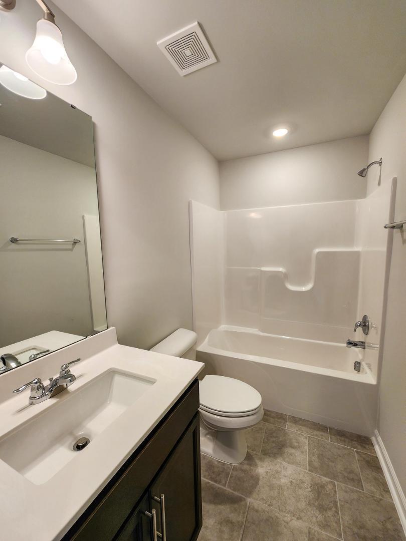 2431 Kasota Lane Raleigh, NC 27610 - Photo 10 of 59 a bathroom with a sink a toilet and shower