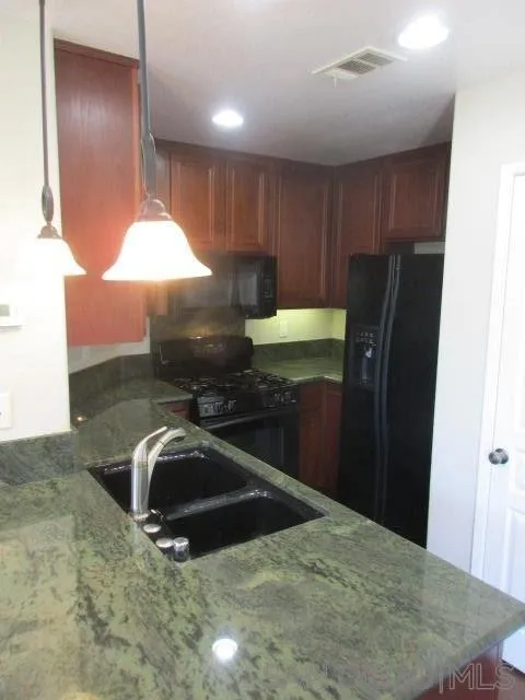 560 Almond Road San Marcos, CA 92078 - Photo 8 of 15 a kitchen with stainless steel appliances a refrigerator a table and chairs