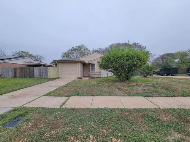 a front view of a house with a yard and potted plants