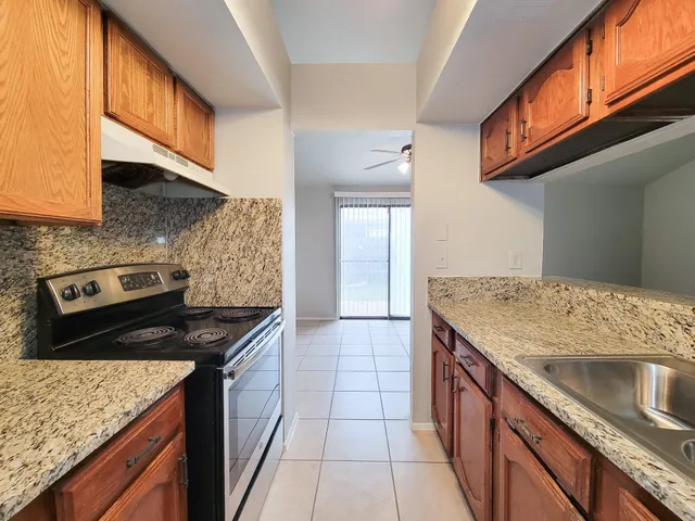 a kitchen with stainless steel appliances granite countertop a sink stove and cabinets