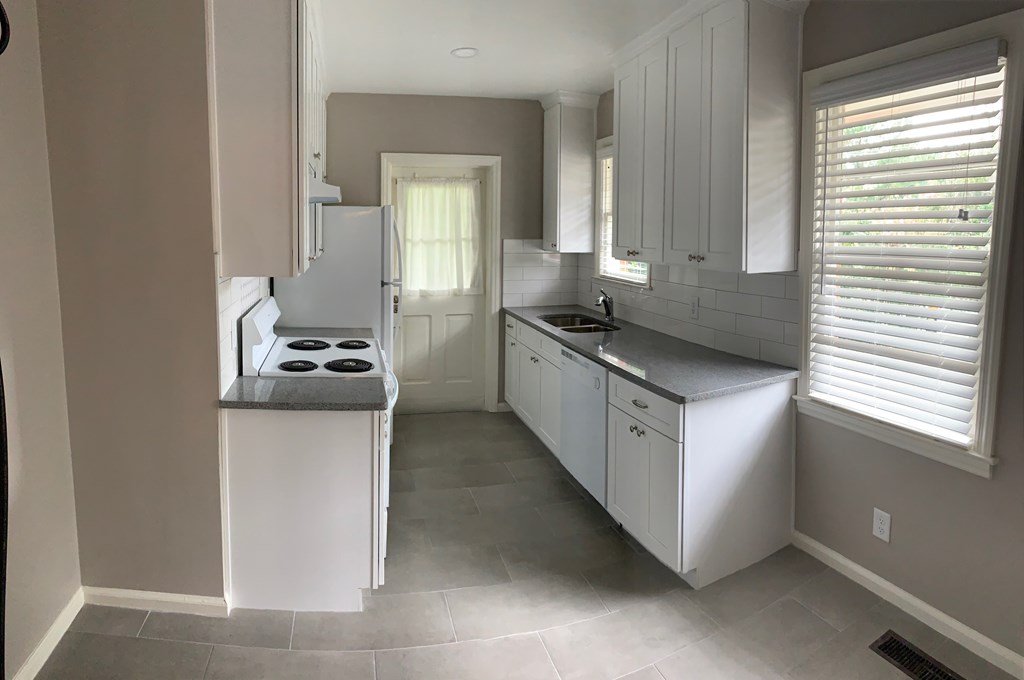 1510 Wildwood Avenue, Unit 1 Columbus, GA 31906 - Photo 3 of 9 a kitchen with stainless steel appliances granite countertop a stove a sink and a refrigerator