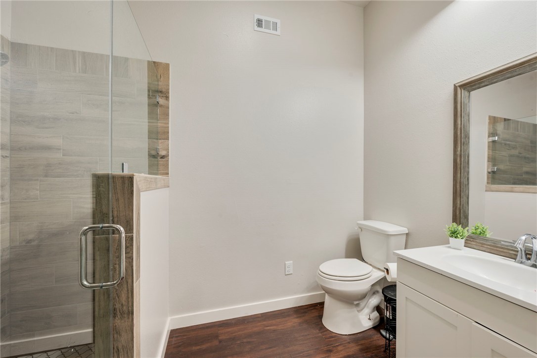 3915 County Road 447 Anderson, TX 77830 - Photo 17 of 40 a bathroom with a granite countertop toilet a sink and a mirror
