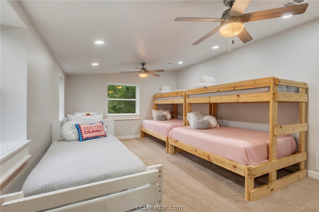 3915 County Road 447 Anderson, TX 77830 - Photo 21 of 40 a bedroom with a large bed and a chandelier