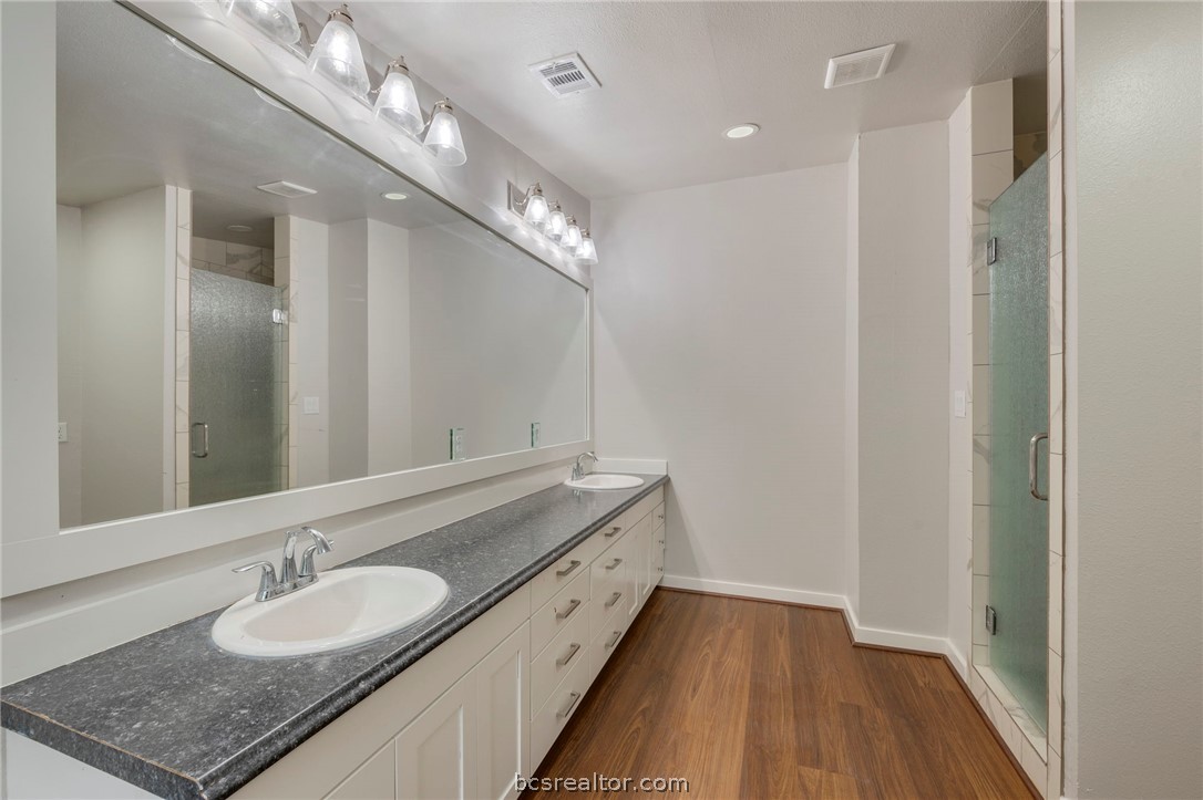 3915 County Road 447 Anderson, TX 77830 - Photo 22 of 40 a spacious bathroom with a granite countertop double vanity and a mirror