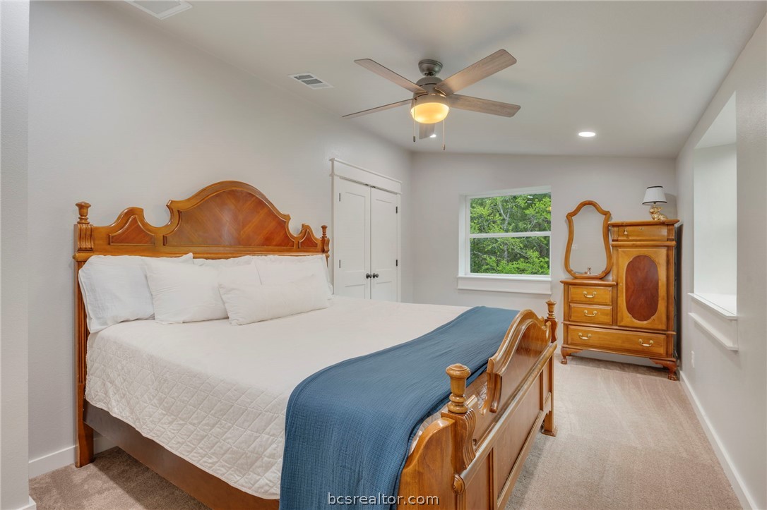 3915 County Road 447 Anderson, TX 77830 - Photo 25 of 40 a bedroom with a bed and a chandelier