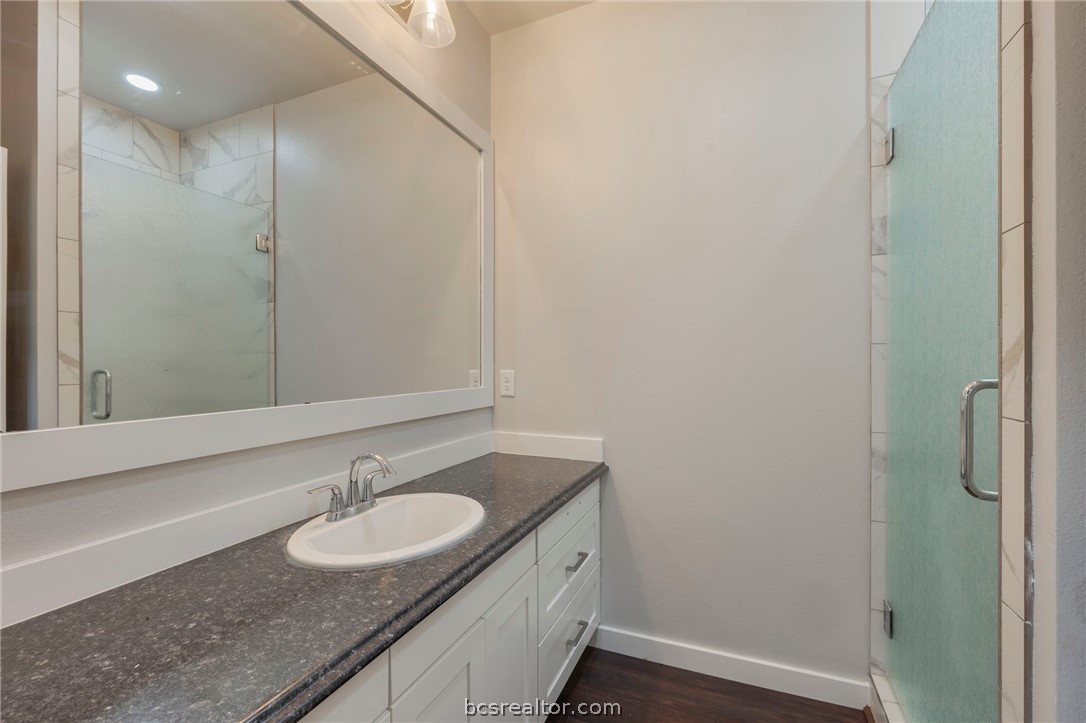 3915 County Road 447 Anderson, TX 77830 - Photo 26 of 40 a bathroom with a granite countertop sink and a mirror