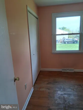 an empty room with wooden floor and a window