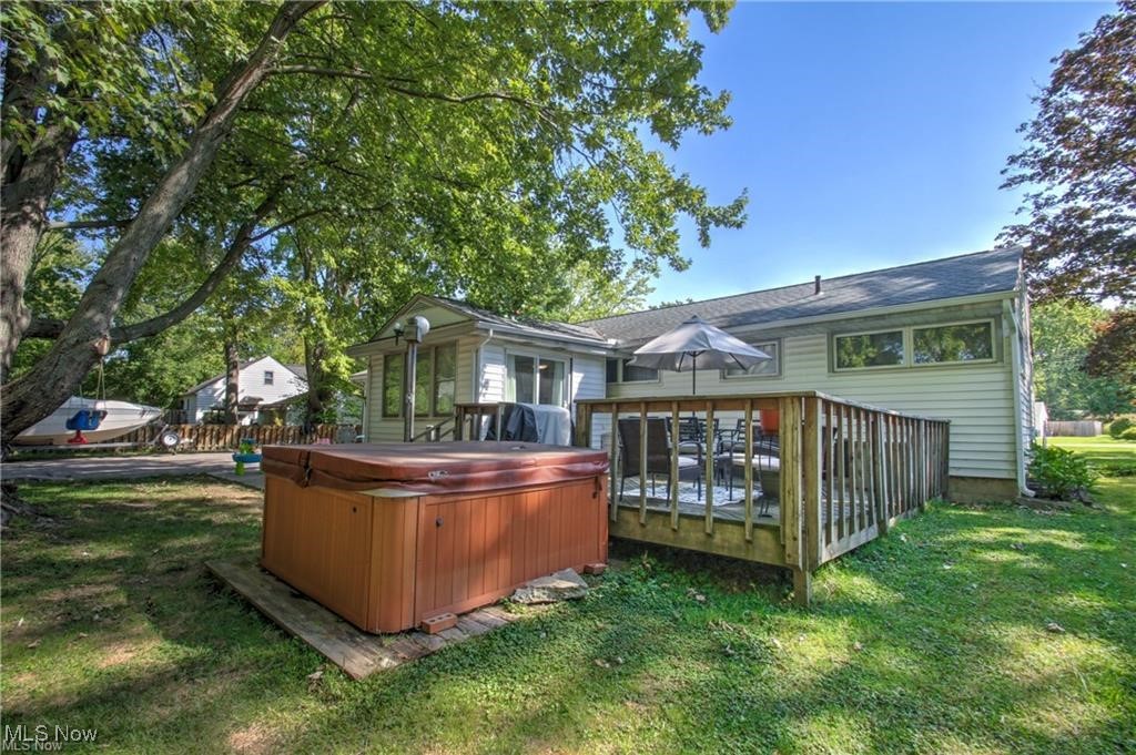 7368 Hopkins Road Mentor, OH 44060 - Photo 28 of 37 Back of house featuring a lawn, a deck, and a hot tub