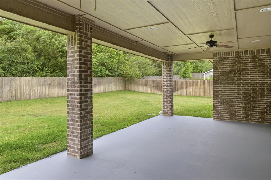 7765 Hickory Spring Lane Tyler, TX 75703 - Photo 35 of 38 Covered patio featuring a painted concrete surface, brick columns, and a matching brick accent wall