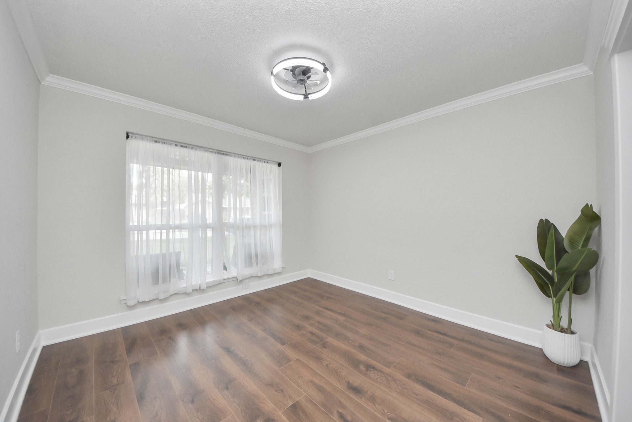 5314 Sweetwind Lane Spring, TX 77373 - Photo 6 of 47 Dining room with elegant laminate flooring, a large window with sheer curtains, and a modern ceiling light.