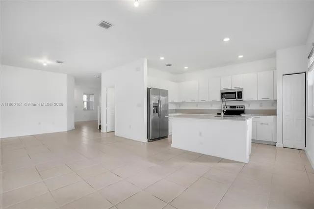 a view of kitchen with refrigerator and microwave