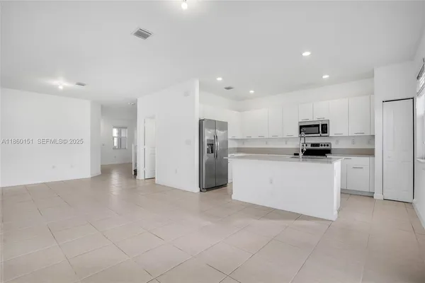 a view of kitchen with refrigerator and microwave