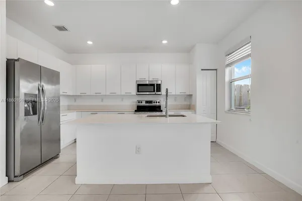 a kitchen with stainless steel appliances granite countertop a refrigerator and a stove