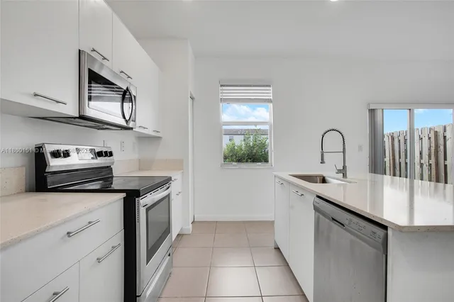 a kitchen with stainless steel appliances granite countertop a sink stove and cabinets