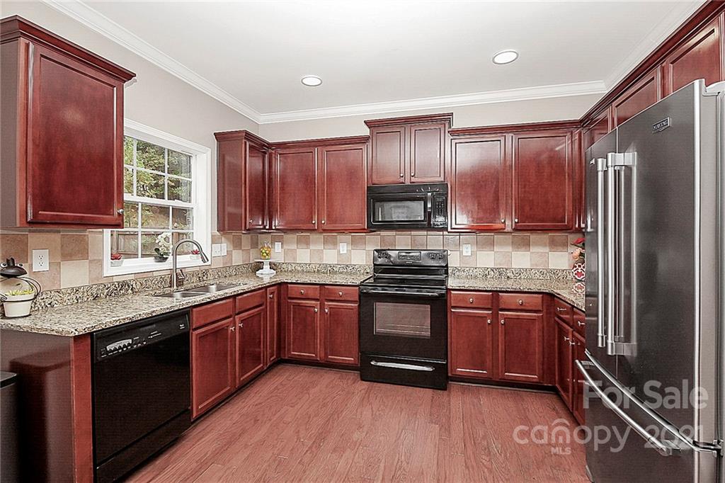 11516 Erwin Ridge Avenue Charlotte, NC 28213 - Photo 13 of 38 a large kitchen with stainless steel appliances granite countertop a refrigerator a stove top oven a sink and dishwasher with wooden floor